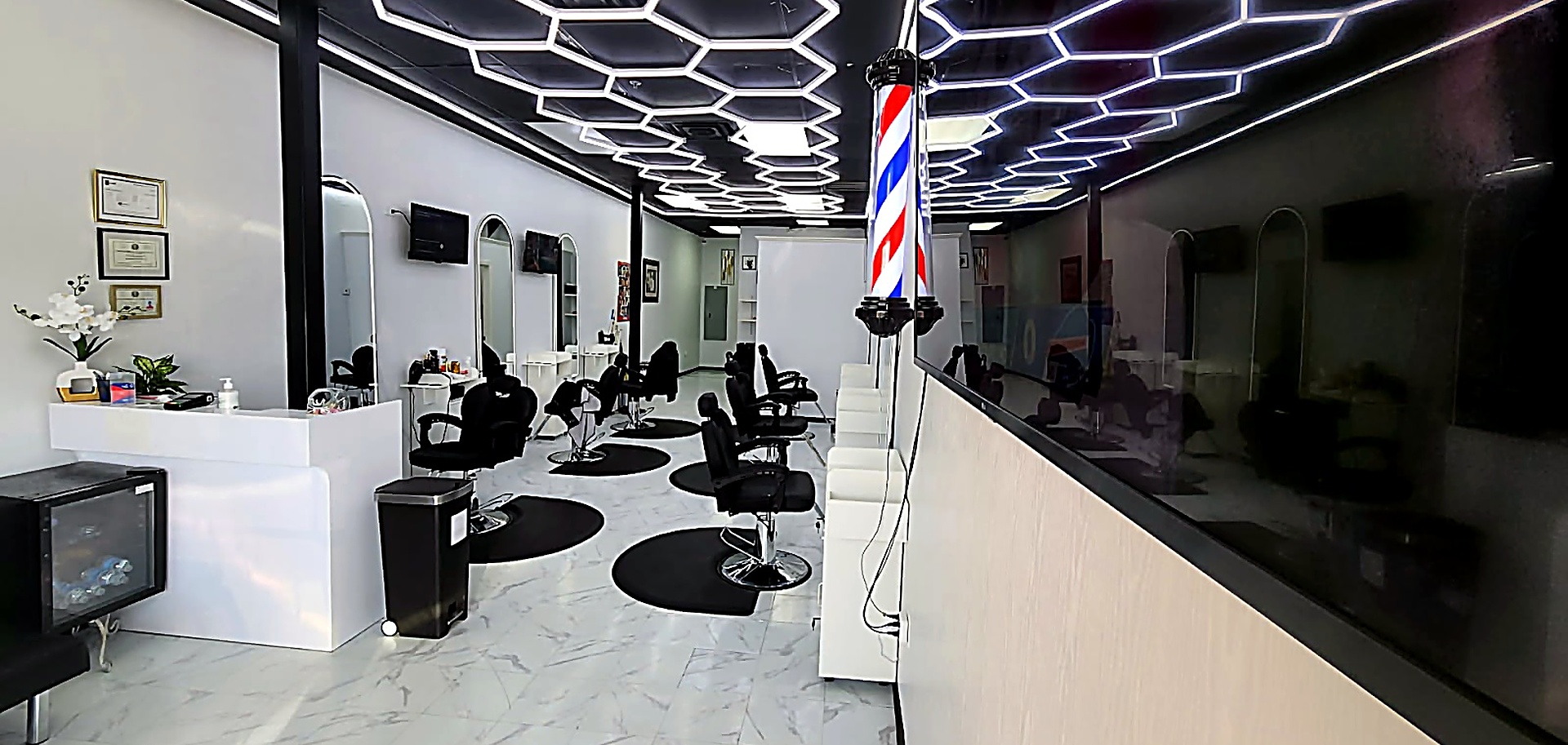 Inside DJ's Barber & Hair Salon — styling chairs, mirror wall and reception desk in Sachse Plaza